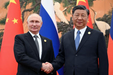 Ruský prezident Vladimir Putin si podáva ruku s čínskym prezidentom Si Ťin-pchingom. FOTO: Reuters
