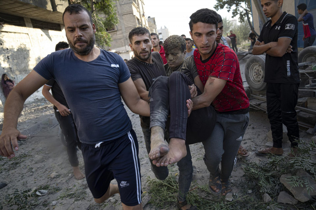 Palestínčania nesú osobu, ktorá utrpela zranenia pri raketovom útoku izraelskej armády v meste Chán Júnis ležiacom v Pásme Gazy. FOTO: TASR/AP