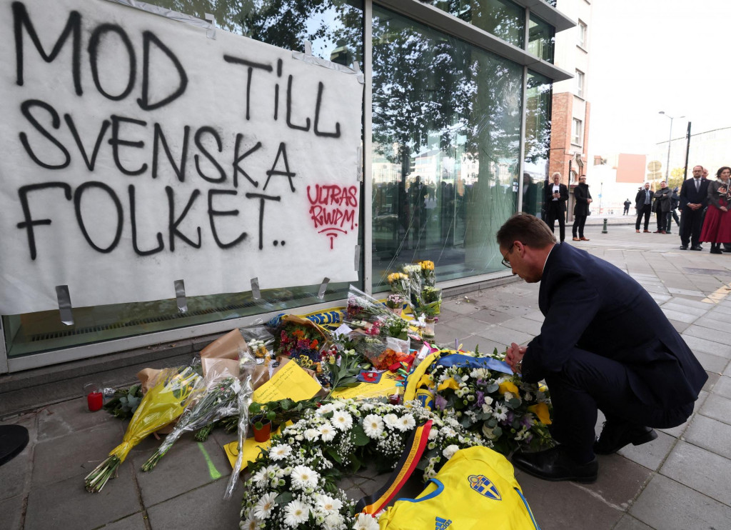 Švédsky premiér Ulf Kristersson vzdáva hold obetiam dva dni po tom, ako strelec zastrelil dvoch Švédov na mieste streľby v Bruseli. FOTO: Reuters