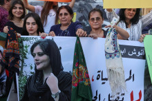 Ženy držia fotografiu Mahsy Aminiovej počas demonštrácie po jej smrti. FOTO: Reuters