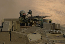Izraelský vojak jazdí na tanku neďaleko hraníc s Libanonom 11. októbra 2023. FOTO: TASR/AP

