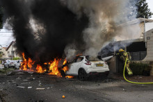 Izraelskí hasiči hasia požiar v juhoizraelskom meste Aškelon po vypálení rakety z pásma Gazy. FOTO: TASR/AP