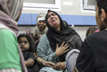 Zranení Palestínčania sedia na dlážke v nemocnici al-Shifa po ich príchode z nemocnice al-Ahli po explózii po tom, ako ju zasiahla raketa v Gaze. FOTO: TASR/AP