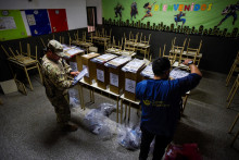 Pracovník a vojenský personál kontrolujú volebné urny a hlasovacie materiály v škole, ktorá sa má použiť ako volebná miestnosť, pred prezidentskými voľbami na predmestí Buenos Aires. FOTO: Reuters