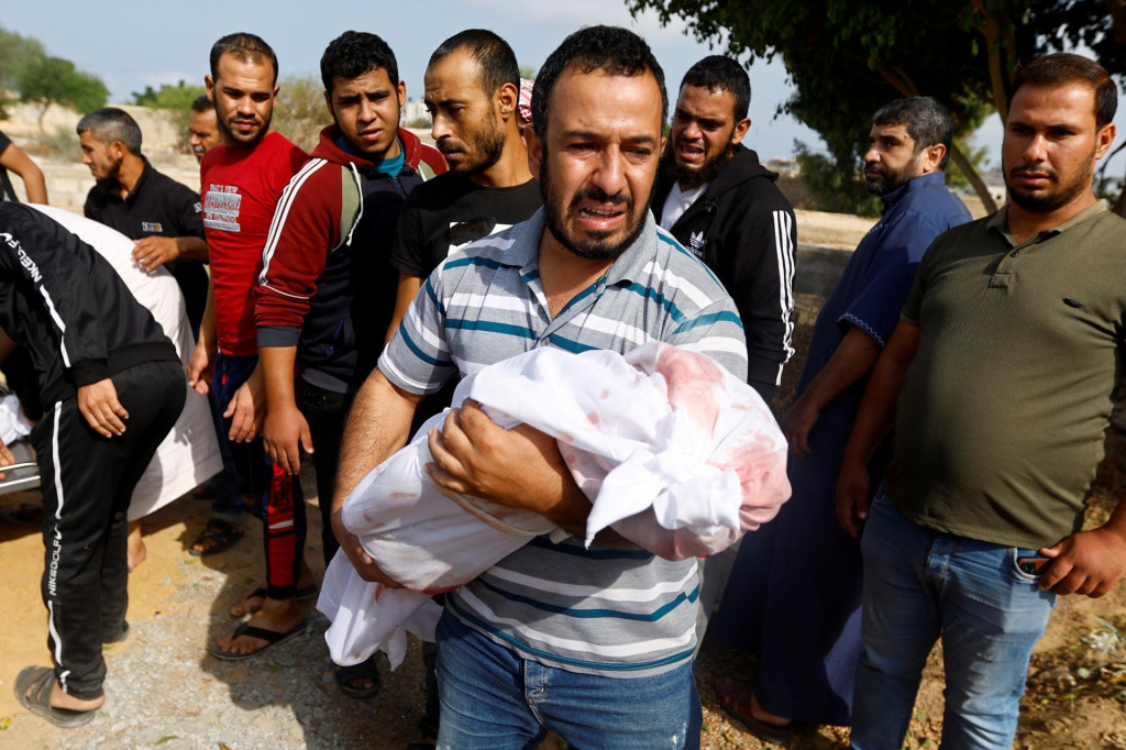 Smútiaci nesie telo dieťaťa počas pohrebu Palestínčanov. FOTO: Reuters