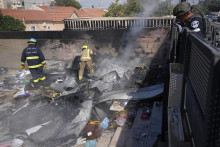 Izraelskí hasiči likvidujú požiar na mieste zasiahnutom raketou vypálenou z pásma Gazy v meste Sderot na juhu Izraela 15. októbra 2023. FOTO: TASR/AP