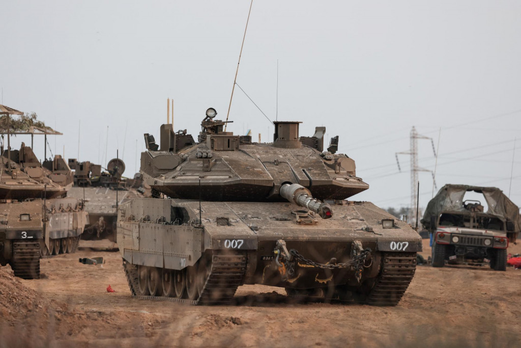 Izraelský tank a vojenské vozidlá pri hraniciach Izraela s pásmom Gazy. FOTO: Reuters