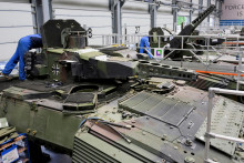 Zamestnanci pracujú na bojových vozidlách Puma na výrobnej linke v závode nemeckej spoločnosti Rheinmetall. FOTO: Reuters
