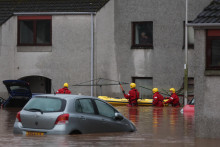 Pohotovostné služby pomáhajú pri evakuácii ľudí z ich domovov počas búrky Babet v Škótsku. FOTO: Reuters