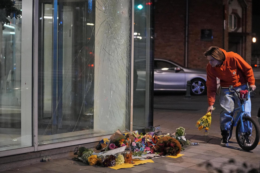 Cyklista kladie kvety na pietne miesto pred budovou v centre Bruselu, neďaleko ktorej extrémista tuniského pôvodu zastrelil v  dvoch švédskych futbalových fanúšikov. FOTO: TASR/AP