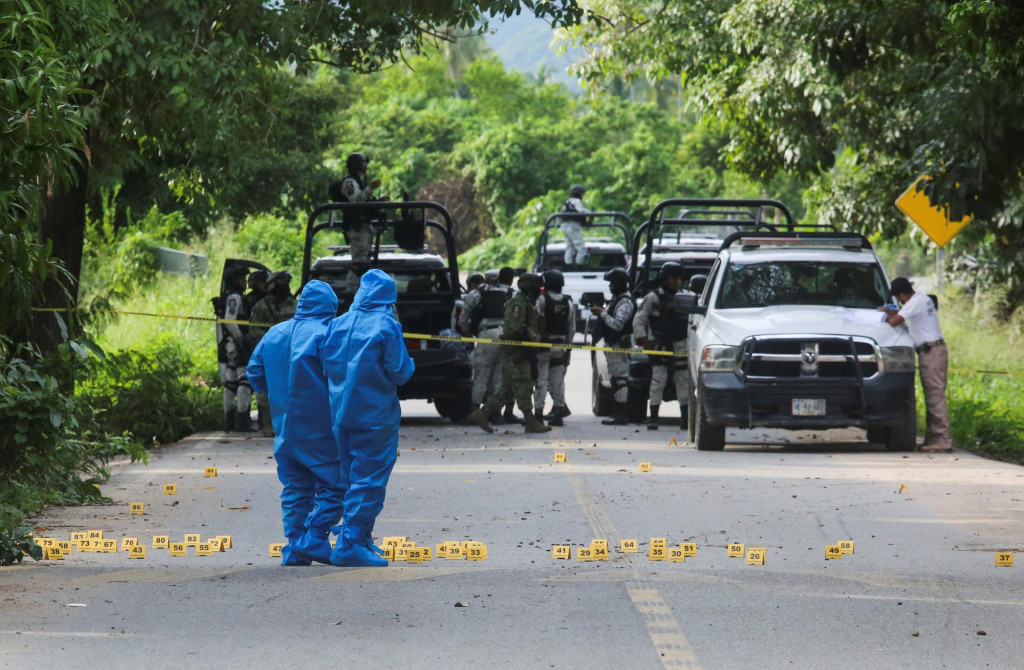 Forenzní technici pracujú na mieste činu, kde ozbrojenci zastrelili niekoľko miestnych policajtov v mexickom meste Coyuca de Beníte. FOTO: Reuters