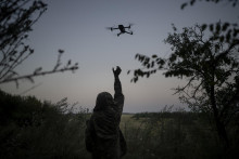 Ukrajinský vojak sa naťahuje za dronom v Luhanskej oblasti. FOTO: TASR/AP