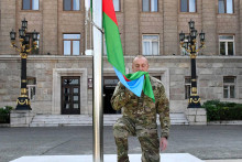 Aazerbajdžanský prezident Ilham Alijev bozkáva vlajku svojej krajiny v hlavnom meste Náhorného Karabachu po jej vztýčení. FOTO: TSAR/AP