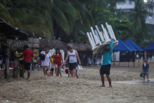 Muž v Acapulcu odstraňuje stoly z pláže, pretože k mestu sa blíži hurikán Otis. FOTO: Reuters