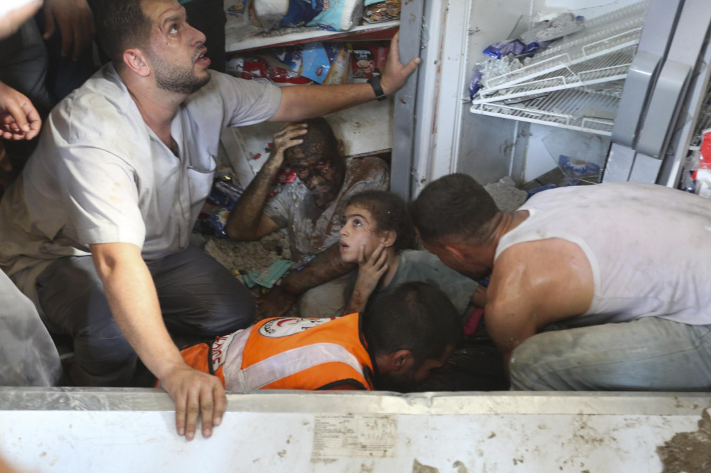 Palestínčania zachraňujú preživších po izraelskom leteckom útoku na pásmo Gazy v meste Rafah. FOTO: TASR/AP
