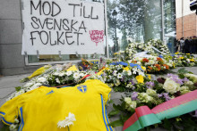 Švédsky dres a kvety ležia na chodníku pred budovou počas pietnej spomienky na obete streľby v centre Bruselu. FOTO: TASR/AP