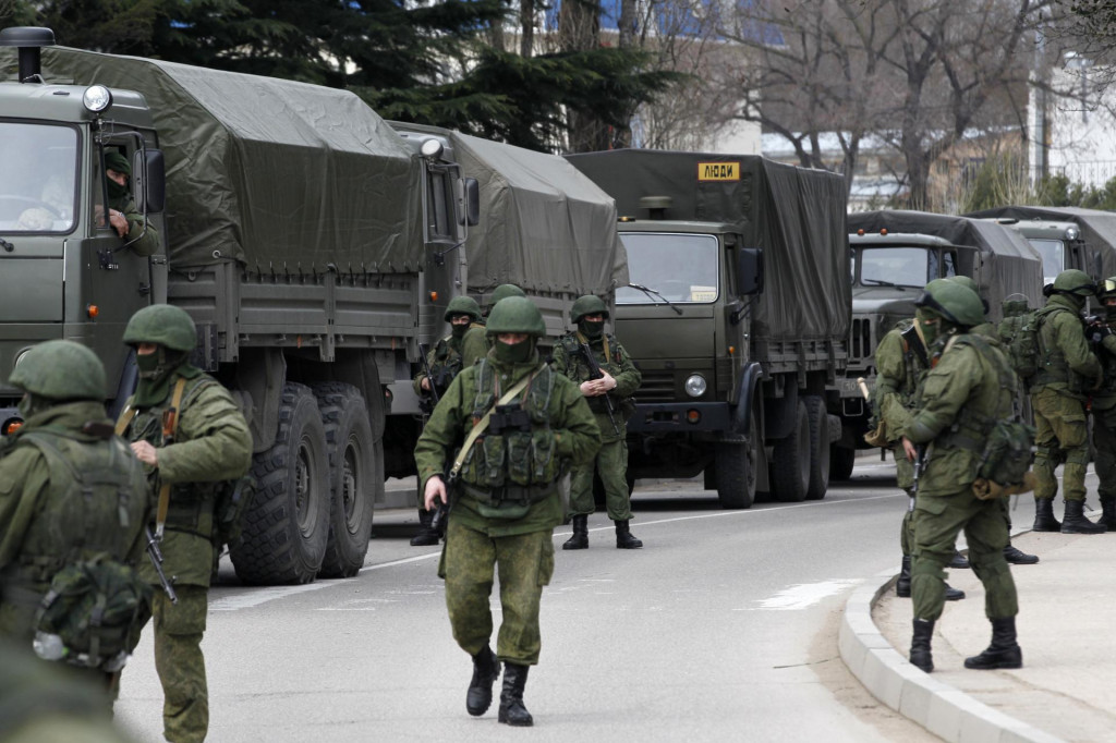Ozbrojení vojaci čakajú v blízkosti vozidiel ruskej armády pred stanovišťom ukrajinskej pohraničnej stráže v krymskom meste Balaclava 1. marca 2014. FOTO: Reuters