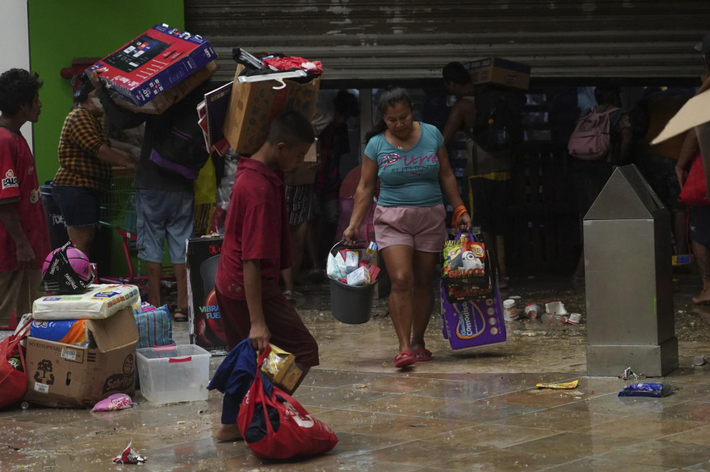 Ľudia rabujú potraviny po vyčíňaní hurikánu Otis v mexickom Acapulcu. Prezident obyvateľov zasiahnutých miest vyzval, aby situáciu nezneužívali. FOTO: TASR/AP