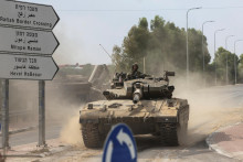 Izraelskí vojaci v tanku pri južných hraniciach Izraela s Gazou. FOTO: REUTERS