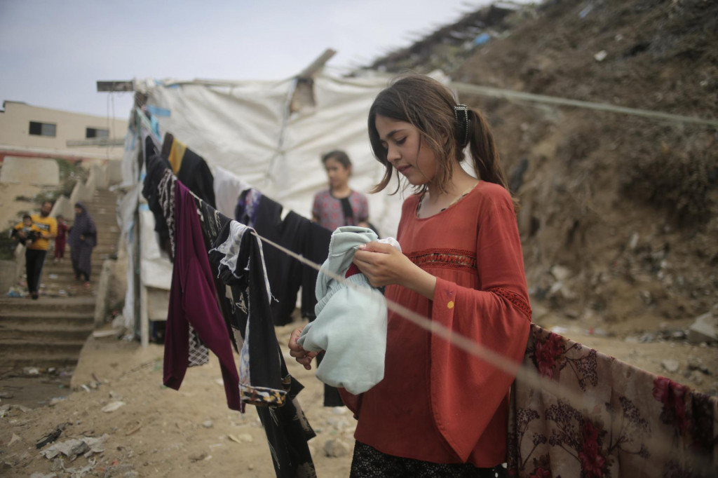 Palestínske dievča vešia bielizeň, ktorú si oprala v morskej vode na pláži v meste Dajr al-Balah v centrálnej časti Gazy. FOTO: TASR/AP