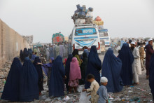 Afganci sa zhromažďujú na autobusovej zastávke v pakistanskom Karáčí, aby sa dostali domov. FOTO: Reuters