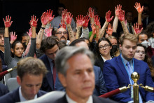 Protivojnoví demonštranti dvíhajú svoje „krvavé“ ruky za americkým ministrom zahraničných vecí Antonym Blinkenom počas vypočutia Senátneho výboru pre rozpočtové prostriedky. FOTO: Reuters