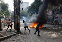 Priaznivci Bangladéšskej nacionalistickej strany hádžu na políciu tehly počas stretu v bengladéšskom meste Dháka. FOTO: Reuters