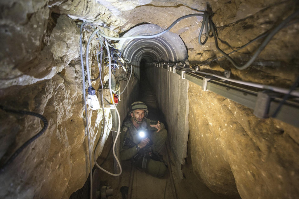 Na archívnej snímke z 25. júla 2014 izraelský vojak ukazuje novinárom tunel, ktorý údajne používali palestínski militanti. FOTO: TASR/AP
