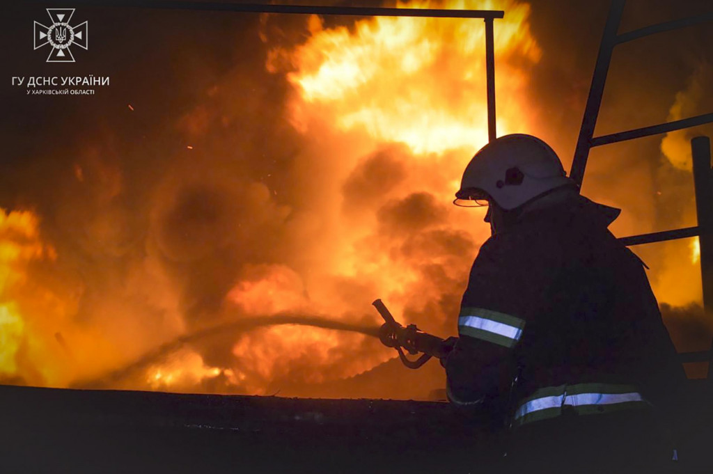 Príslušník záchranných zložiek hasí požiar po ruskom dronovom útoku v meste Charkov na východe Ukrajiny. FOTO: TASR/AP