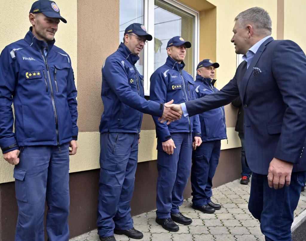Predseda vlády Robert Fico (vpravo) si podáva ruku s hasičmi počas príchodu na stretnutie so starostami obcí postihnutých zemetrasením v obci Ďapalovce. FOTO: TASR/Roman Hanc