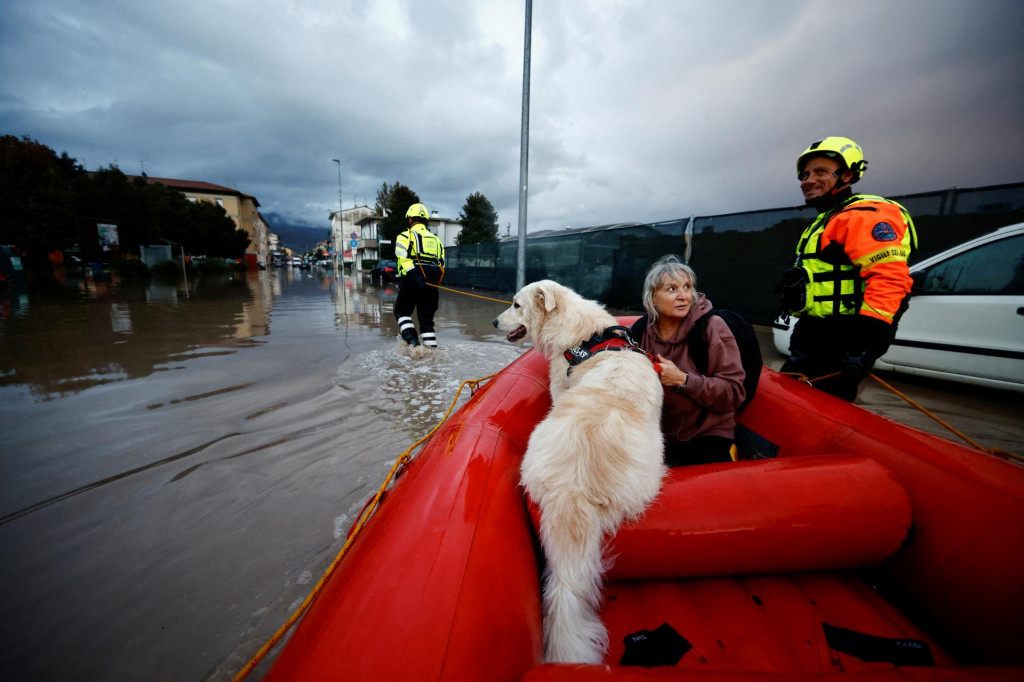 Obyvatelia talianskeho mesta Oste sú prevážaní na hasičskom člne po tom, čo boli zachránení po búrke Ciarán. FOTO: Reuters