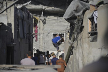 Palestínčania prehľadávajú preživších v troskách zničeného domu po izraelskom leteckom útoku na pásmo Gazy v utečeneckom tábore Nusseirat. FOTO: TASR/AP
