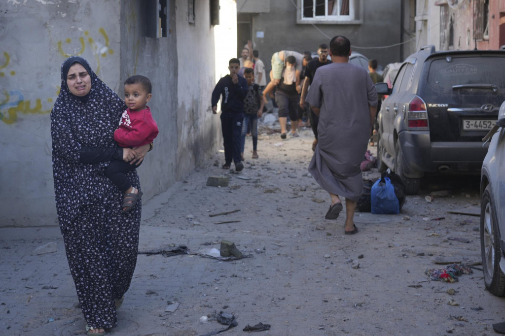 Palestínčanka nesie svoje dieťa po izraelskom leteckom útoku na pásmo Gazy v utečeneckom tábore Nusseirat 4. novembra 2023. FOTO: TASR/AP