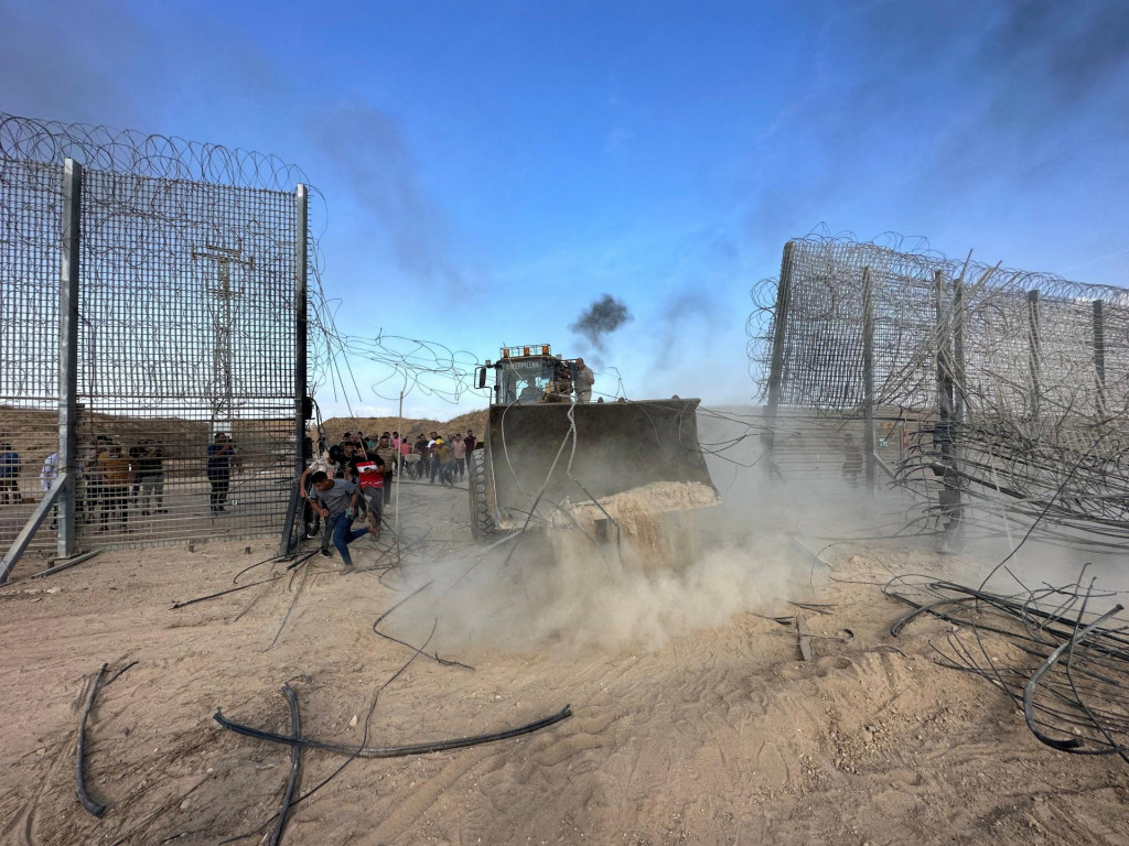 Palestínčania prenikli na izraelskú stranu hraničného plotu medzi Izraelom a Gazou po tom, čo ozbrojenci prenikli do oblastí južného Izraela. FOTO: Reuters