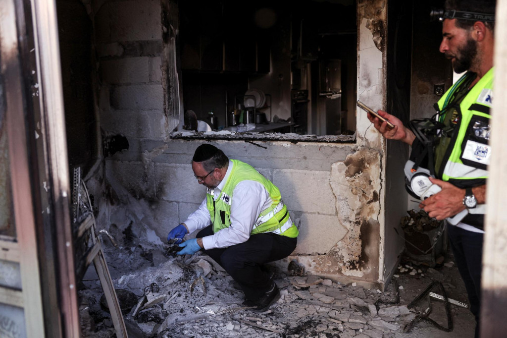 Členovia pátracieho a záchranného tímu ZAKA prehľadávajú dom, ktorý bol prepadnutý počas smrtiaceho útoku ozbrojencov Hamasu. FOTO: Reuters