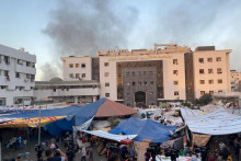 Dym stúpa, keď sa vysídlení Palestínčania ukrývajú v nemocnici. FOTO: Reuters