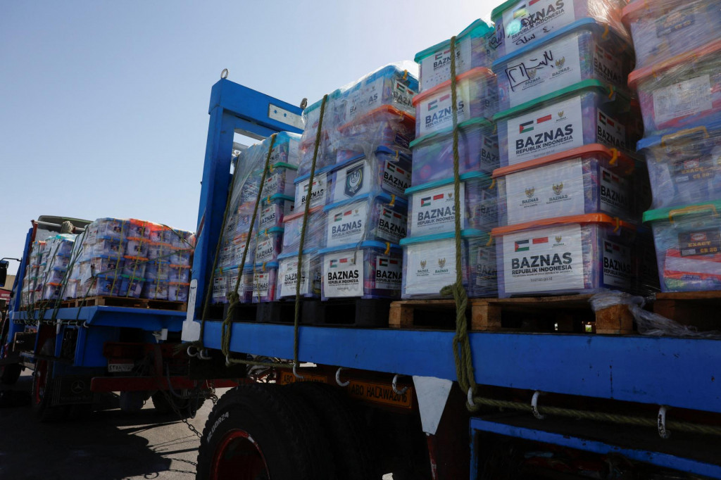 Škatule s humanitárnymi zásobami smerujúcimi do Gazy sú naukladané na kamióne. FOTO: Reuters