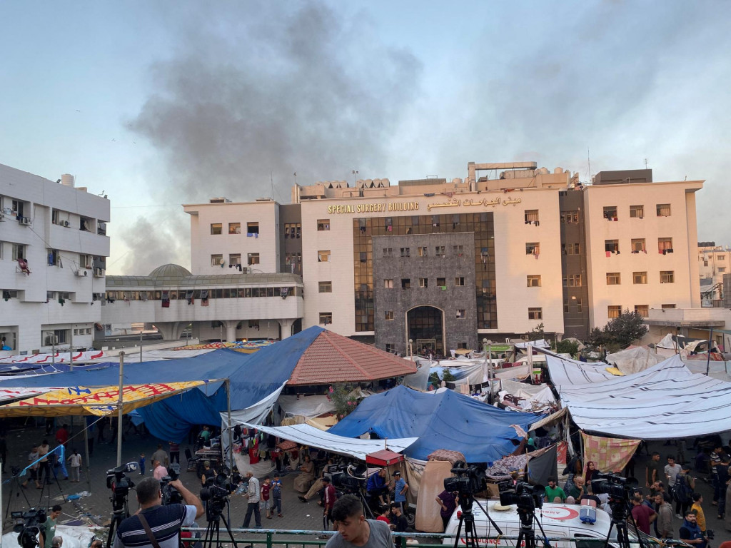 Dym stúpa, keď sa vysídlení Palestínčania ukrývajú v nemocnici. FOTO: Reuters