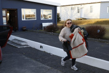 Obyvateľka islandského mesta Grindavík si odnáša časť vecí zo svojho domu v pondelok. FOTO: TASR/AP
