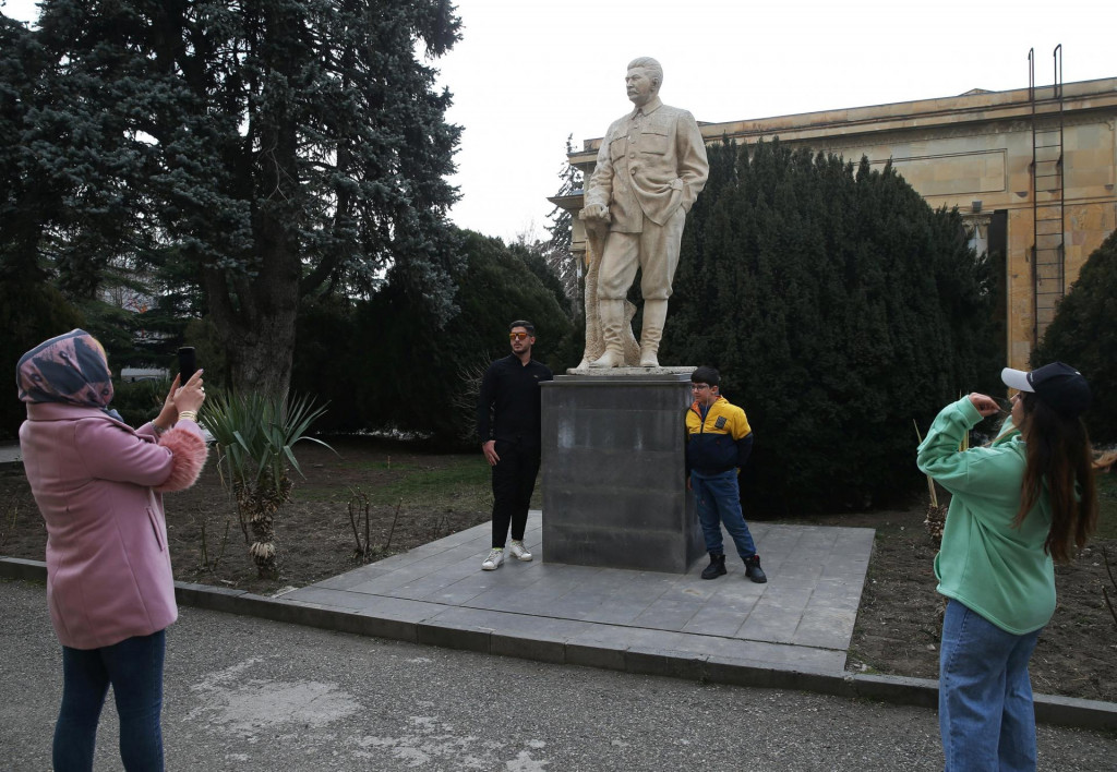 Ľudia sa fotografujú vedľa Stalinovej sochy. FOTO: Reuters
