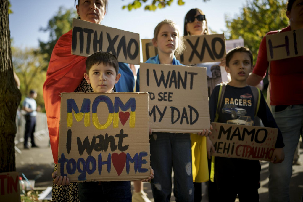Ukrajinské deti držia transparenty s nápismi ”Mami, chcem sa vrátiť späť domov alebo Chcem vidieť svojho otca” počas protestu pred ruskoým veľvyslanectvom v Bukurešti. FOTO: TASR/AP