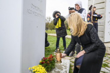 Prezidentka Zuzana Čaputová zapaľuje sviečku pri pamätníku Antona Srholca na Devíne. FOTO: TASR/Jaroslav Novák
