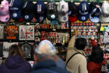 Turisti kupujú predmety v darčekovom stánku v Londýne. FOTO: Reuters