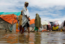Obyvatelia sa brodia záplavovou vodou v provizórnych prístreškoch v tábore Al-Hidaya pre vnútorne vysídlené osoby po silných dažďoch na predmestí Mogadiša. FOTO: Reuters