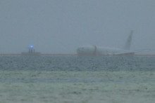 Hliadkové lietadlo amerického vojenského námorníctva P-8A prešlo pristávaciu dráhu a skončilo v morskom zálive na Havaji. FOTO: TASR/AP