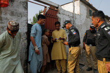 Pakistanskí policajti s úradníkmi kontrolujú občianske preukazy afganských občanov počas podomového overovania a pátrania. FOTO: REUTERS