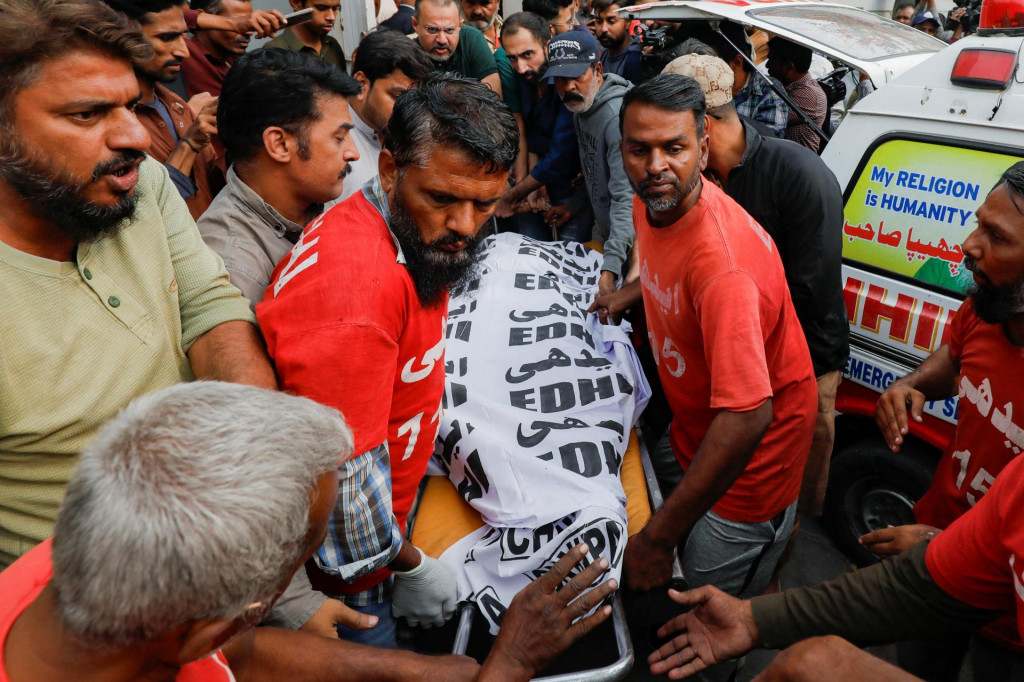 Záchranári premiestňujú telo muža, ktorý zomrel po požiari vo viacposchodovom nákupnom stredisku v Karáčí. FOTO: REUTERS