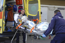 Zdravotníci prevážajú do sanitky človeka, ktorý prežil potopenie lode na gréckom ostrove Lesbos v Egejskom mori. FOTO: TASR/AP