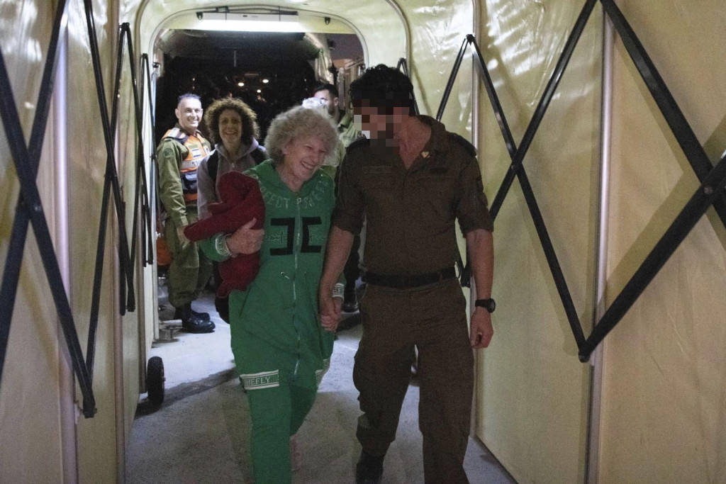 Prepustená izraelská rukojemníčka Ruth Munderová kráča s izraelským vojakom krátko po svojom príchode do Izraela 24. novembra 2023. FOTO: TASR/AP
