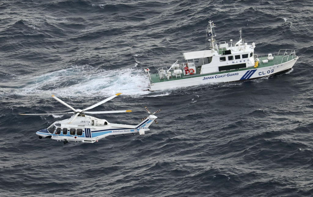 Plavidlo japonskej pobrežnej stráže a vrtuľník vykonávajú pátraciu a záchrannú operáciu na mieste, kde sa americké vojenské lietadlo V-22 Osprey zrútilo do mora pri ostrove Jakušima. FOTO: REUTERS